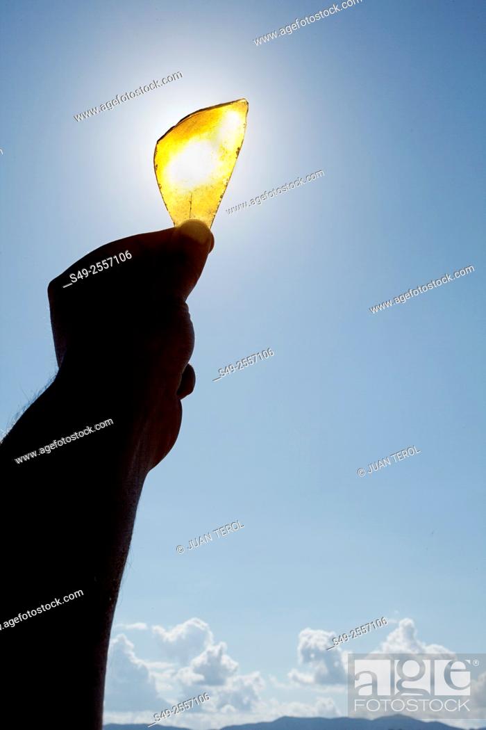 Stock Photo: Detail of person 'catching' the sun in a glass piece.
