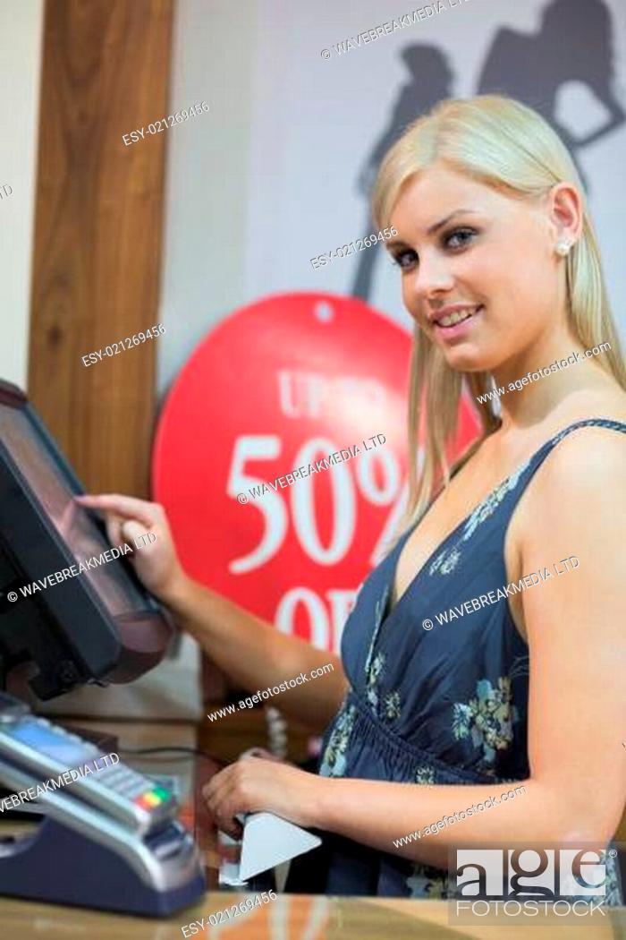 Photo de stock: Woman is standing behind counter while typing at the till.