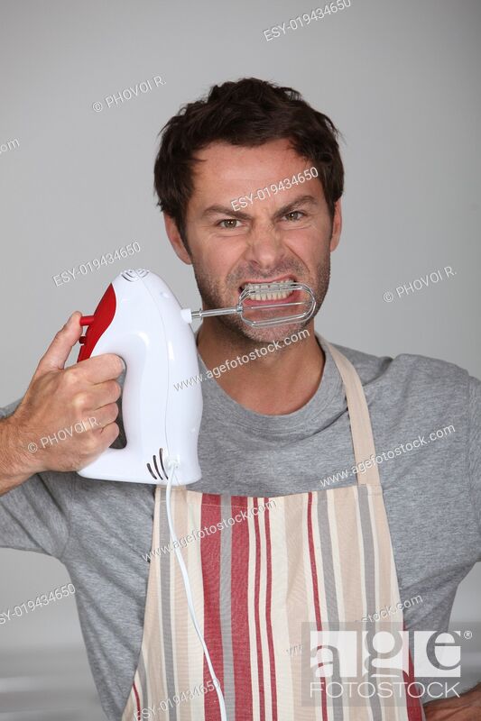 Stock Photo: Aggressive chef wielding an electric hand mixer.