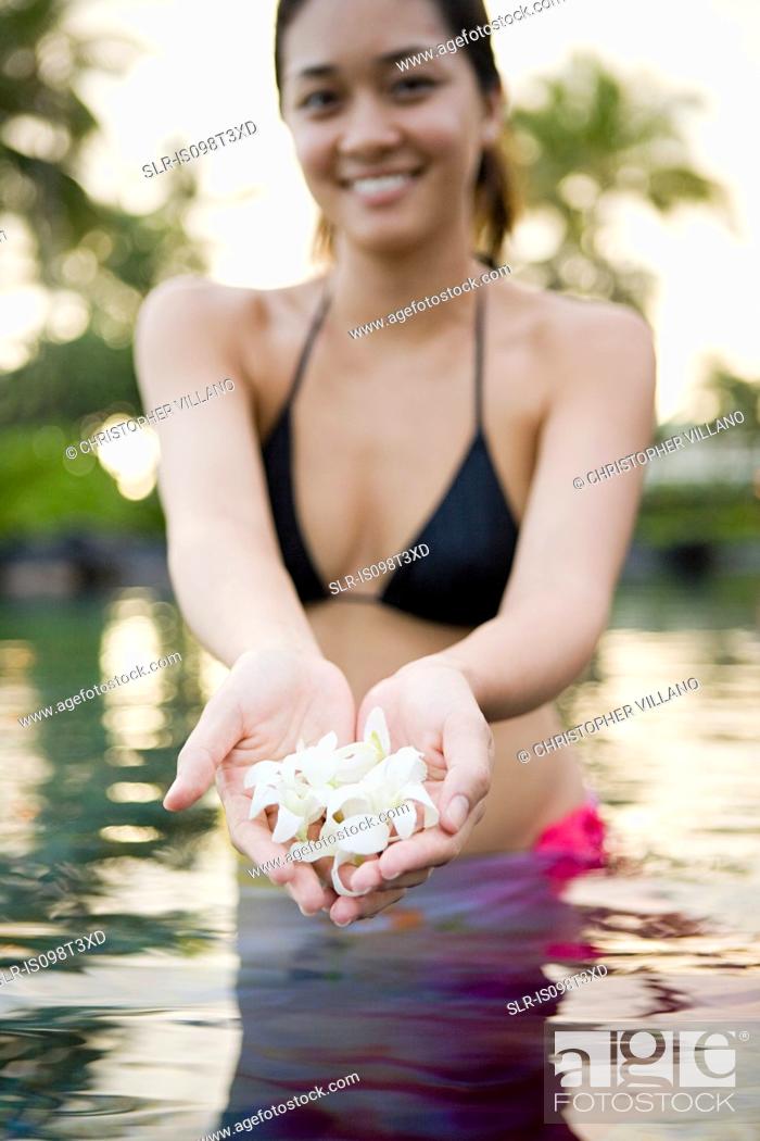 Photo de stock: Woman in water holding flowers.