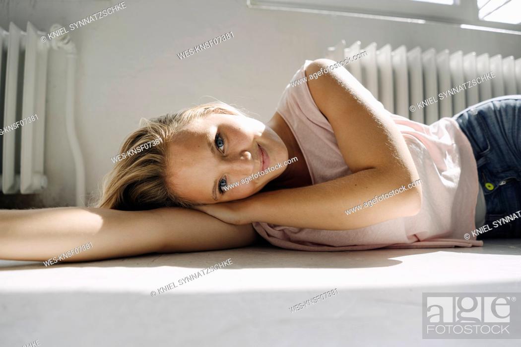 Stock Photo: Portrait of blond young woman lying on the floor.