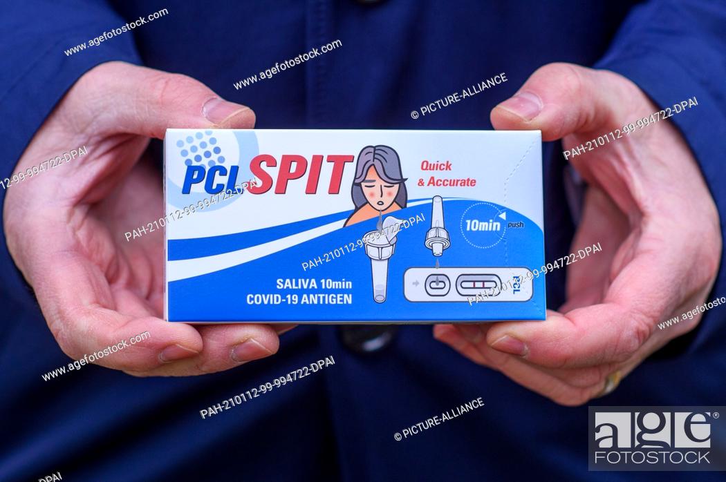 Stock Photo: 12 January 2021, Saxony-Anhalt, Magdeburg: ""PCL Spit"" is written on a package of a spit saliva Covid 19 antigen test. Next to it.