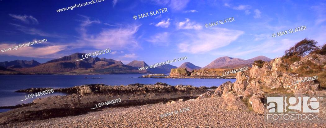 Stock Photo: Scotland, Isle of Skye, Sleat, Panoramic view of mountains with beach and rocky coastline in foreground.