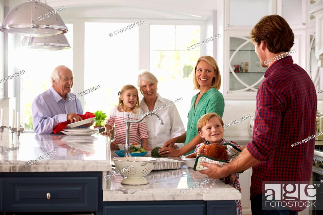 Stock Photo: Family With Grandparents Make Roast Turkey Meal In Kitchen.