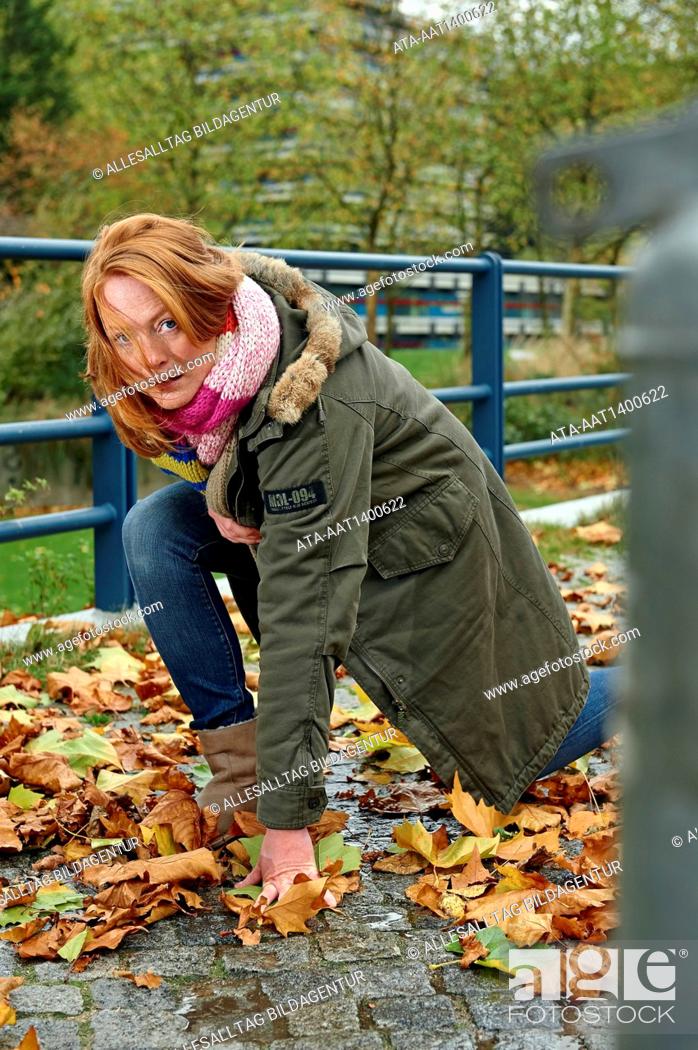 Stock Photo: Woman slipping on wet autumn foliage.