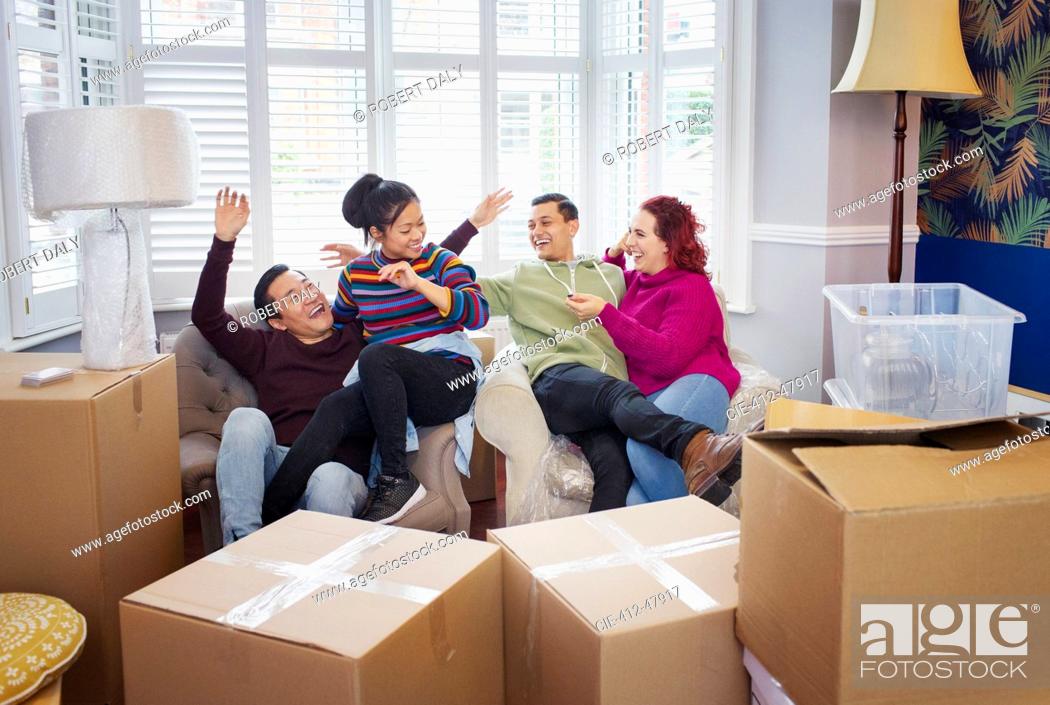 Stock Photo: Happy friends taking a break from moving, celebrating.