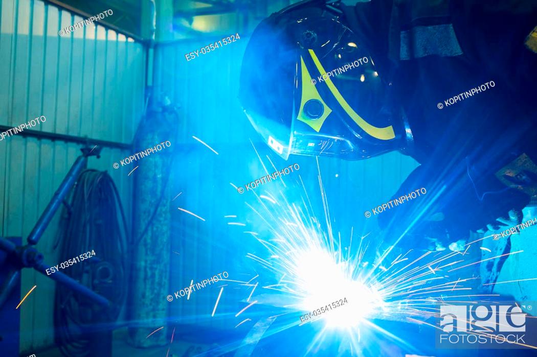 Stock Photo: welder works with electric welding machine. metall.