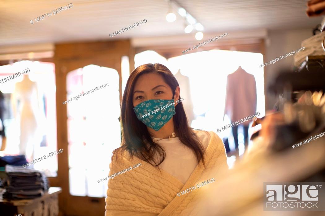 Stock Photo: Portrait confident female shopper in face mask in clothing boutique.