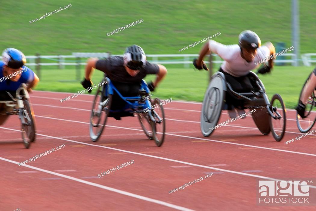Stock Photo: Determined paraplegic athlete speeding along sports track in wheelchair race.