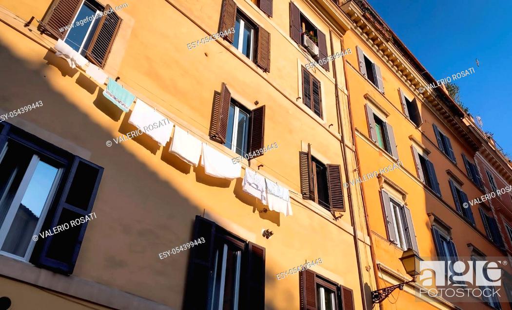 Stock Photo: bottom view with wide angle of ancient stately buildings in the center of rome. In a building there are clothes hanging out to dry in the sun.