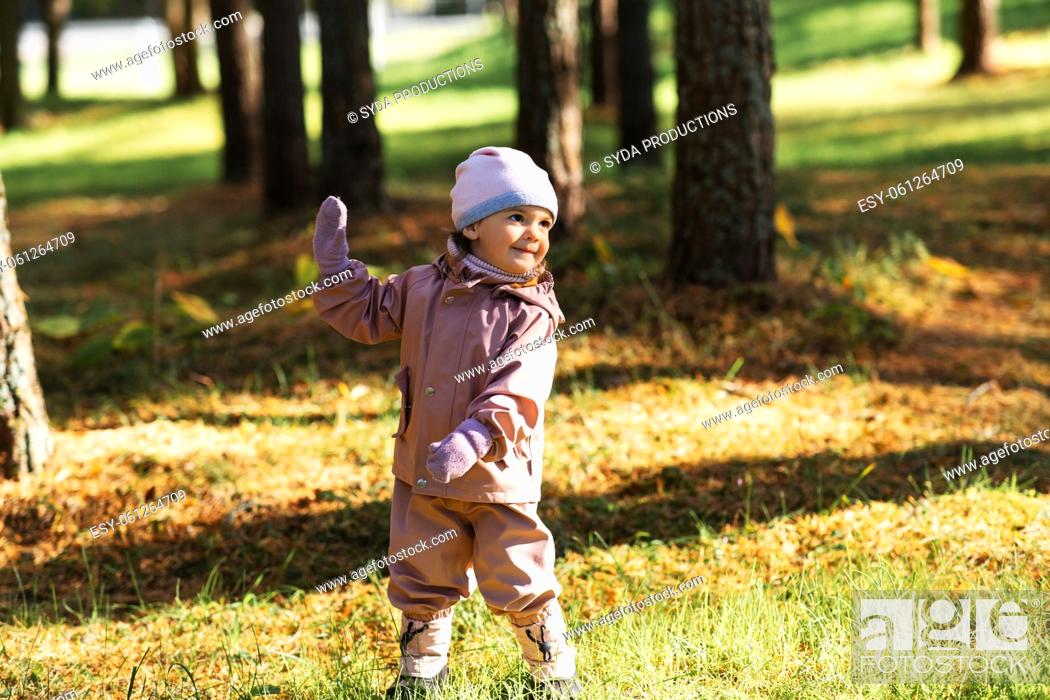 Stock Photo: happy little baby girl walking in autumn park.