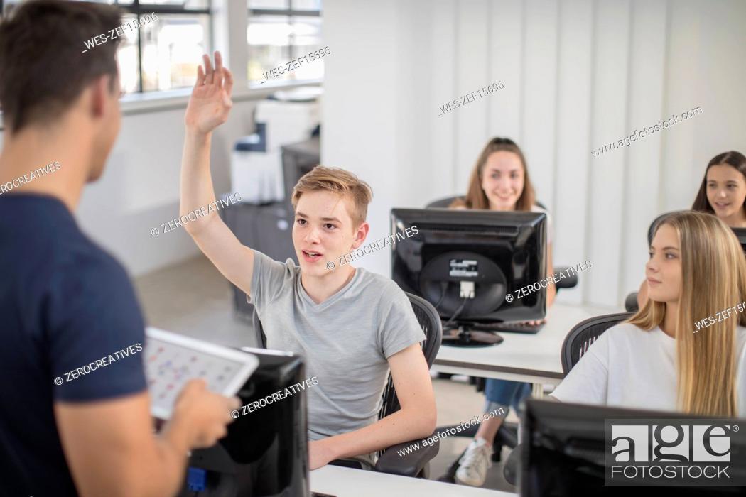 Stock Photo: Boy raising hand in computer class.
