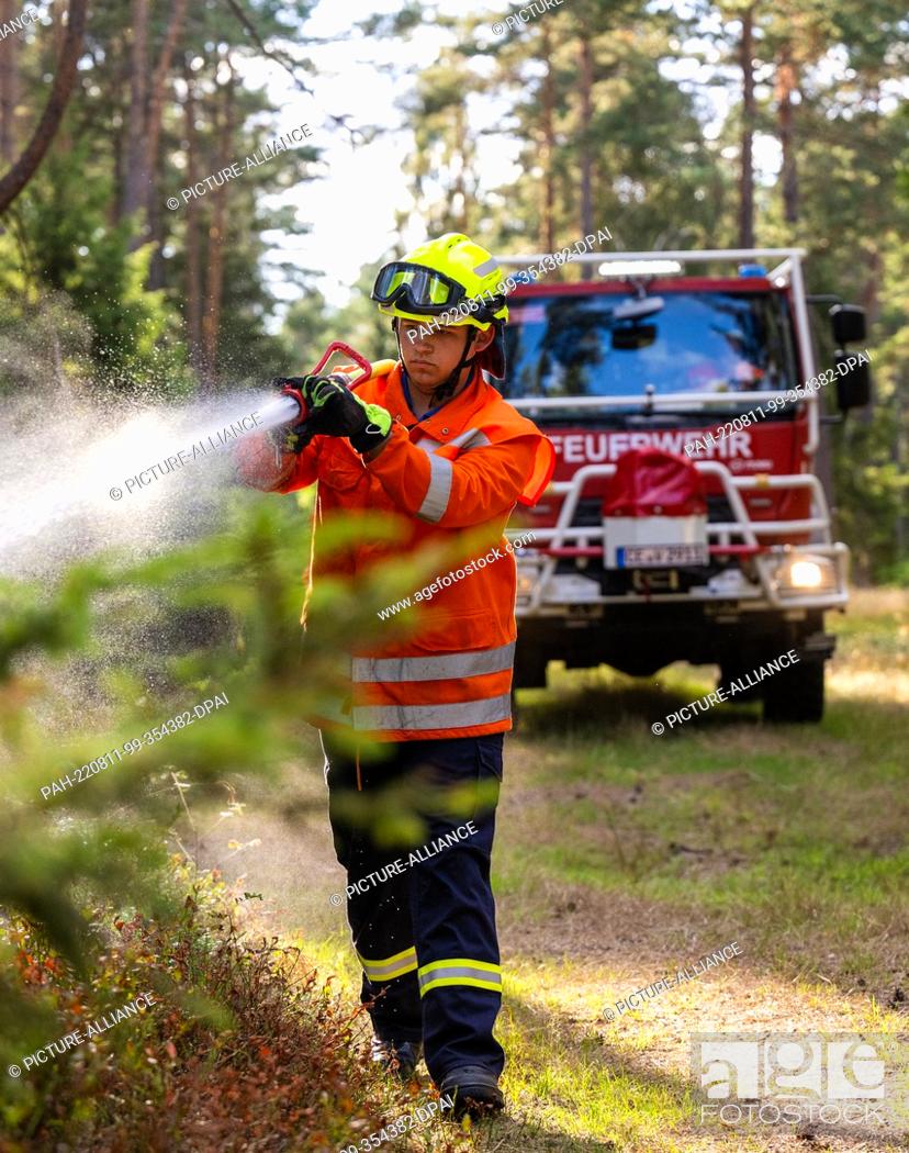 Stock Photo: PRODUCTION - 09 August 2022, Lower Saxony, Wietzendorf: Volunteer firefighters practice the use of the forest fire tanker ""CCFM 3000"".