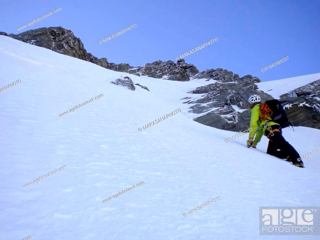 Stock Photo: male mountain guide climbing a steep snow couloir on his way to a high summit in the Swiss Alps.
