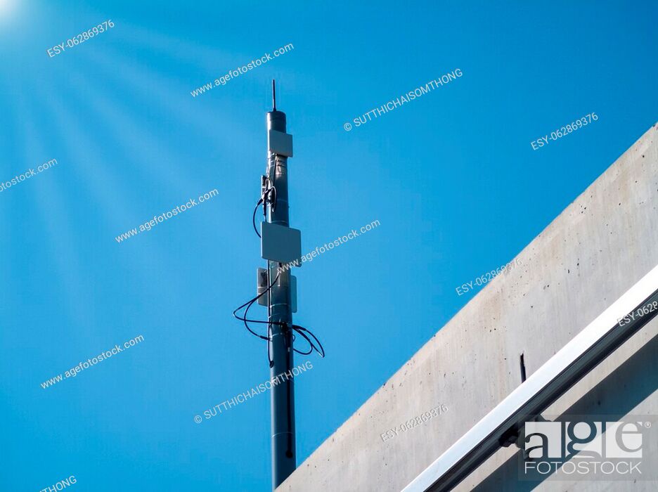 Photo de stock: Antenna mast (communication-based train control system) for electric train and lens flare white. Blue background.