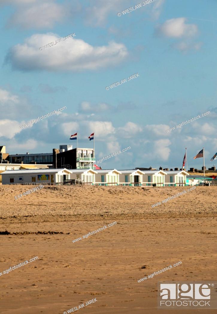 Stock Photo: Katwijk, Netherlands - April 23, 2017: Row white beach houses at the Dutch coast in Katwijk, Netherlands.