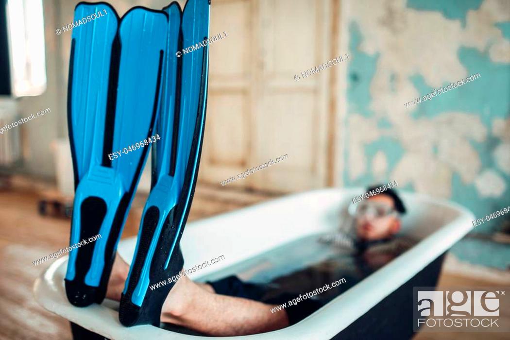 Stock Photo: Funny businessman in flippers and mask lies in bathtub, humor. Business lottery concept.