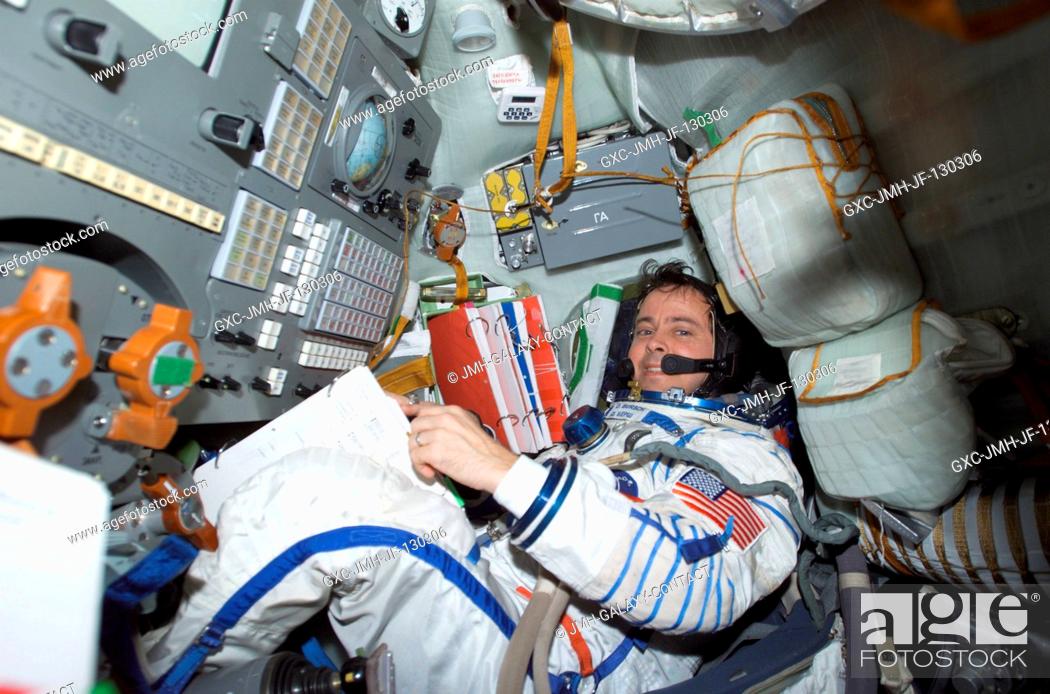 Stock Photo: Astronaut Daniel W. Bursch, Expedition Four flight engineer, wearing a Russian Sokol suit, is seated in the Soyuz 3 spacecraft that is docked to the.