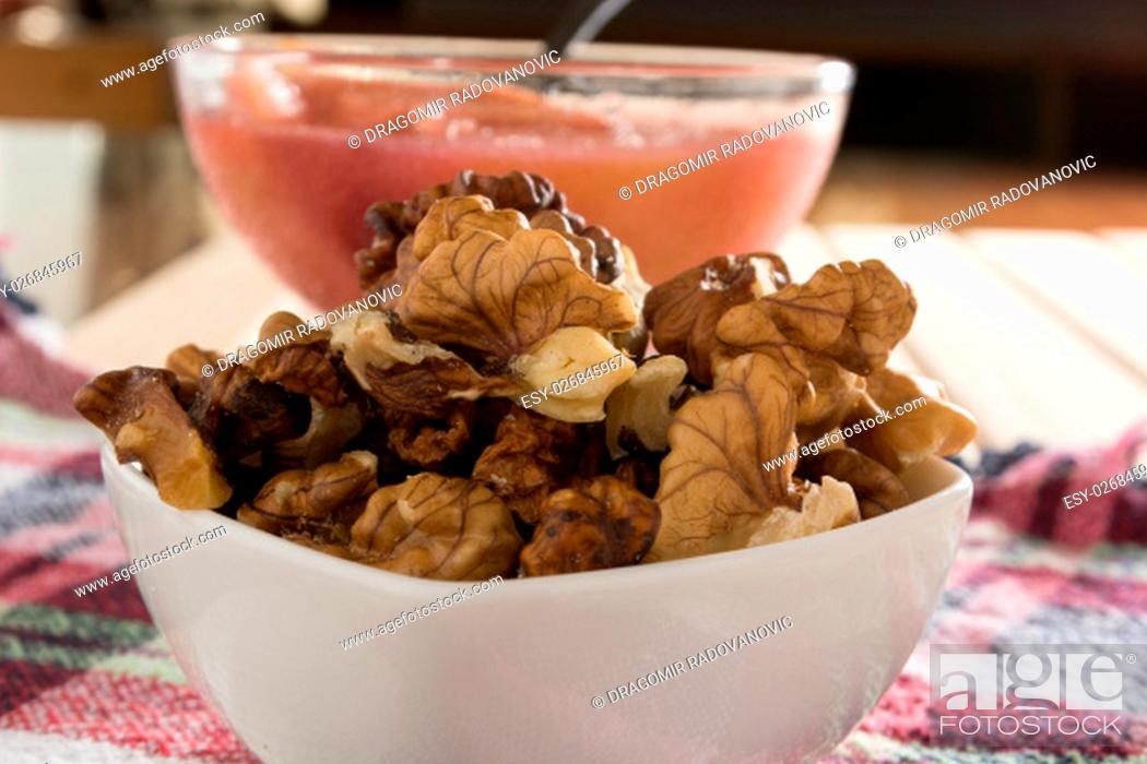 Stock Photo: Apple compote with dried fruits in the cup on wooden table with decorative wallnuts.