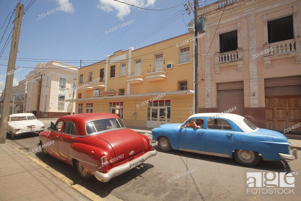 Stock Photo: Old American cars in front of the colonial buildings with balconies at the city center, Cienfuegos, Cuba, Central America.