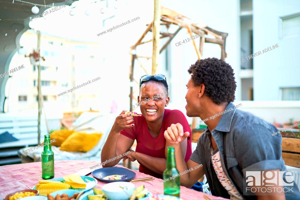 Stock Photo: Happy young couple eating lunch at patio table.