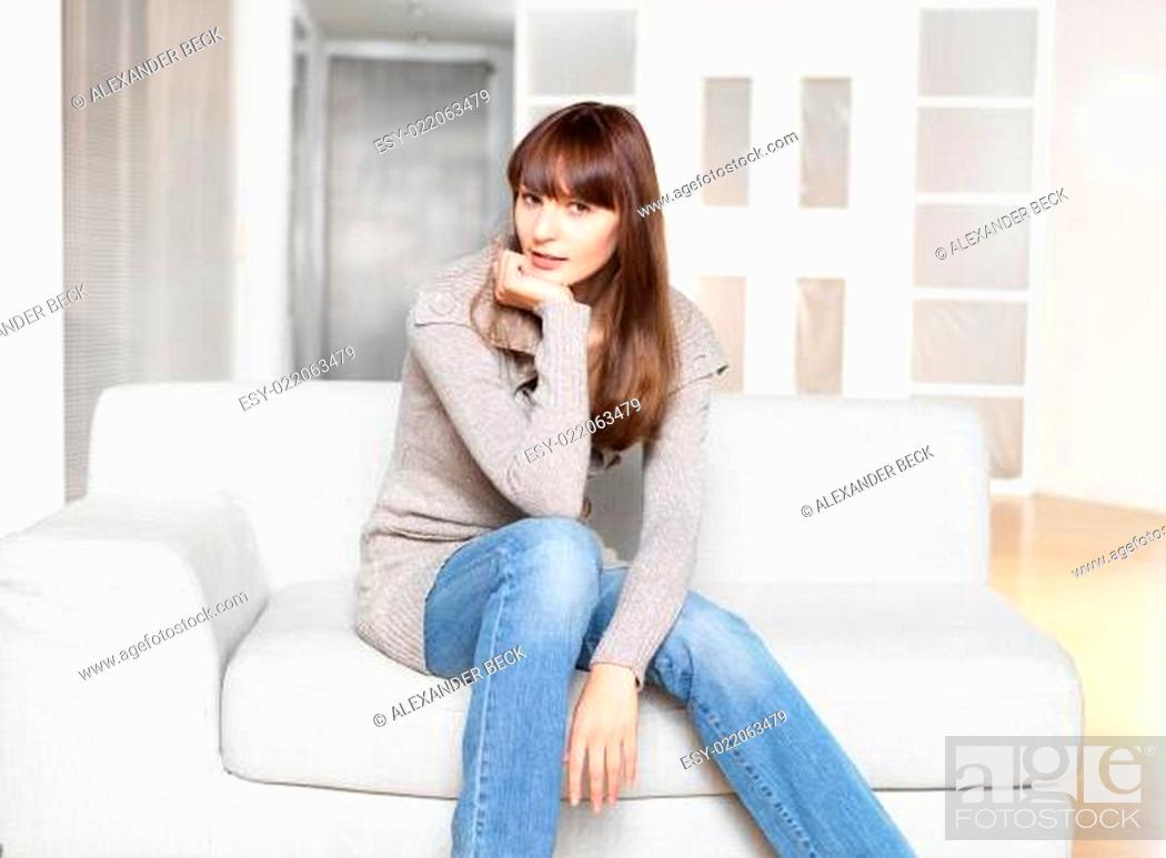 Stock Photo: Junge Frau sitzt auf Sofa.