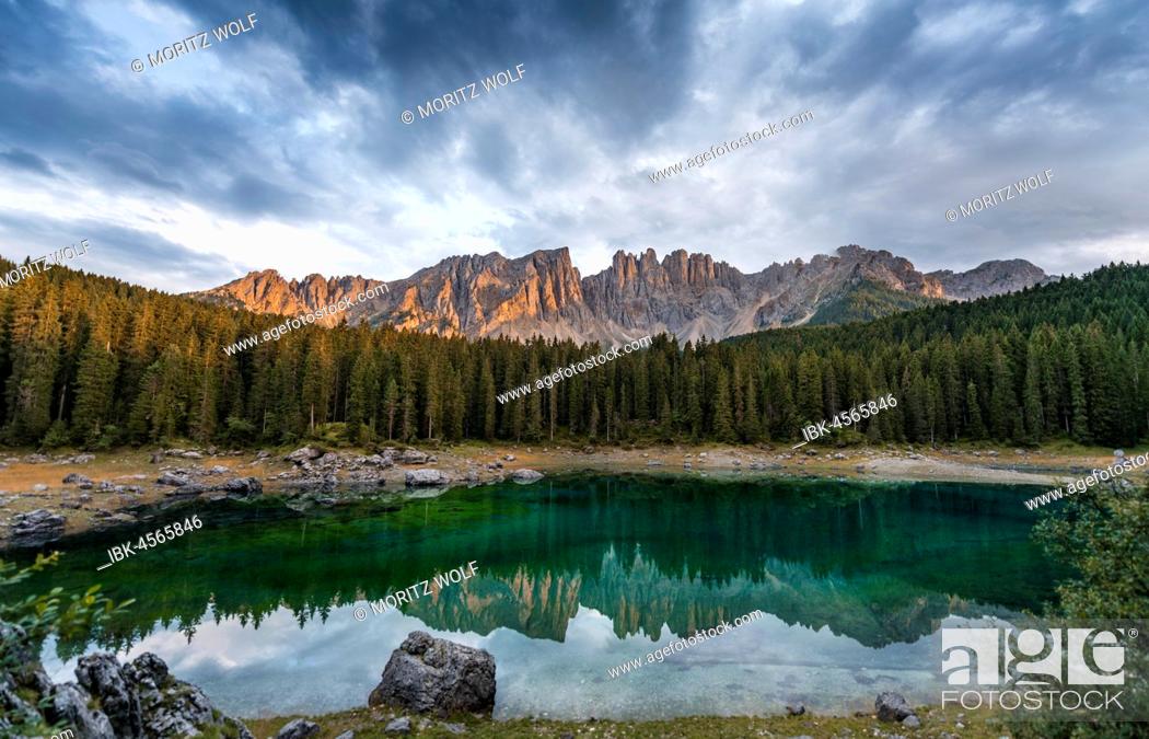 Stock Photo: Sunset, dramatic clouds, Latemar group reflected in the Karersee, Diamantidturm, mountain peaks, Eastern Latemarspitze, Col Coron, Lago di Carezza, Welschnofen.