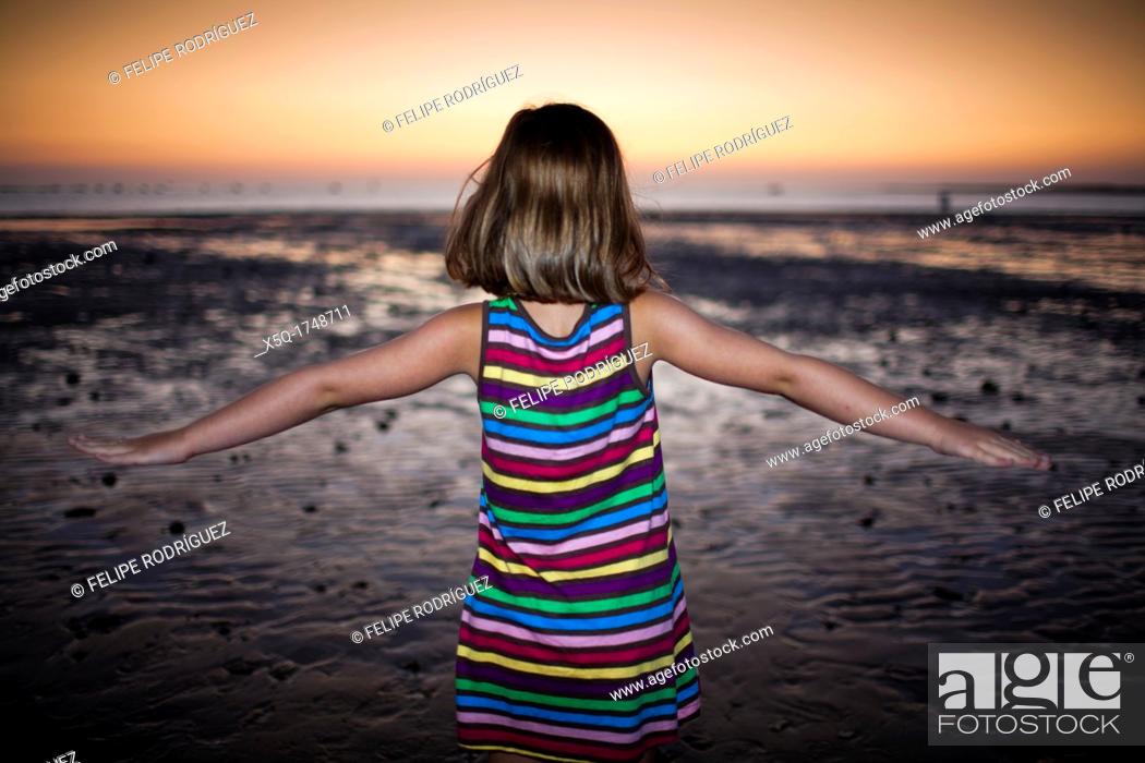 Stock Photo: Little girl on the beach at dusk, Spain.