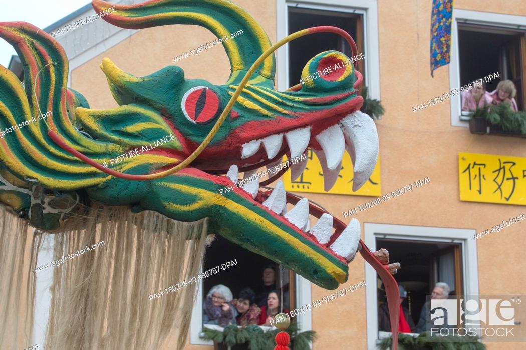 Stock Photo: A group with a Chinese dragon attend the traditional carnival parade in Dietfurt, Germany, 8 February 2018. Every year fools walk through the village dressed as.
