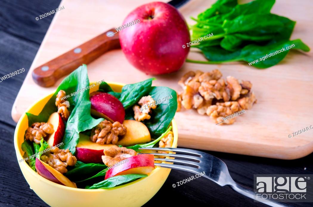 Stock Photo: Spinach salad with nuts and apples served on table.
