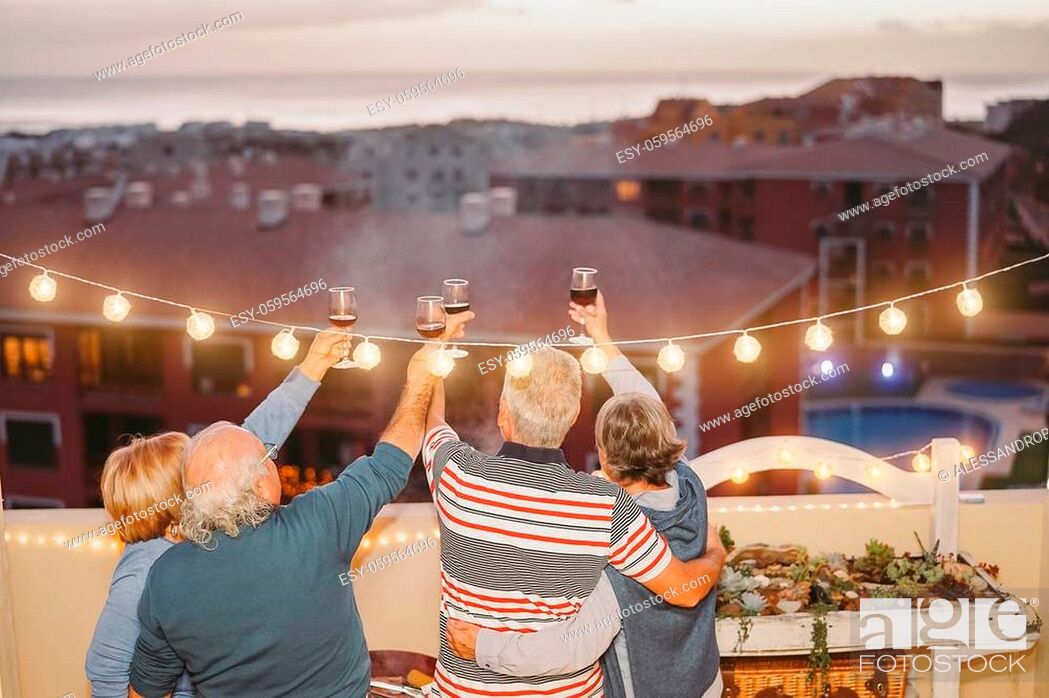 Stock Photo: Happy senior friends cheering and toasting with red wine on rooftop - Mature people having fun and drinking at barbecue party in terrace - Concept of friendship.