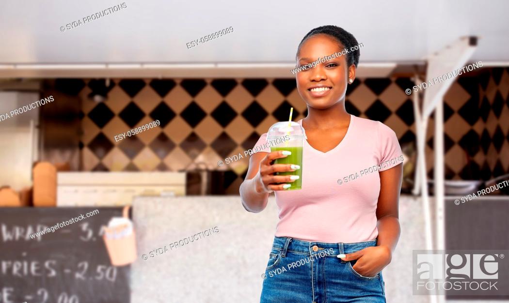 Stock Photo: african american woman with juice over food truck.
