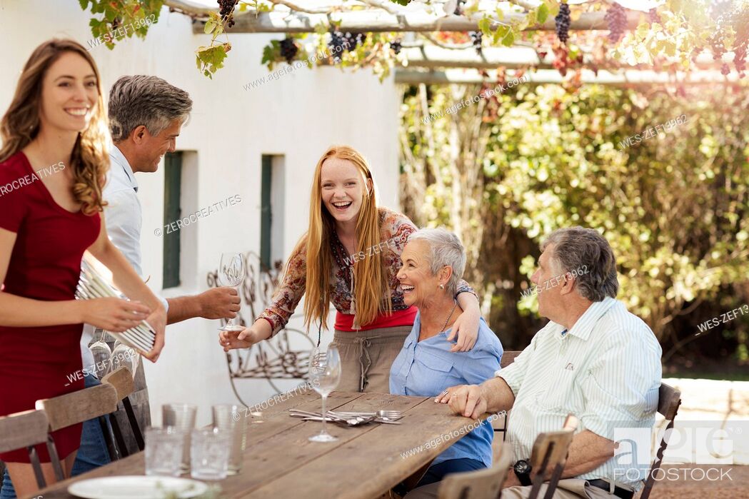 Stock Photo: Happy family setting table outside for lunch.