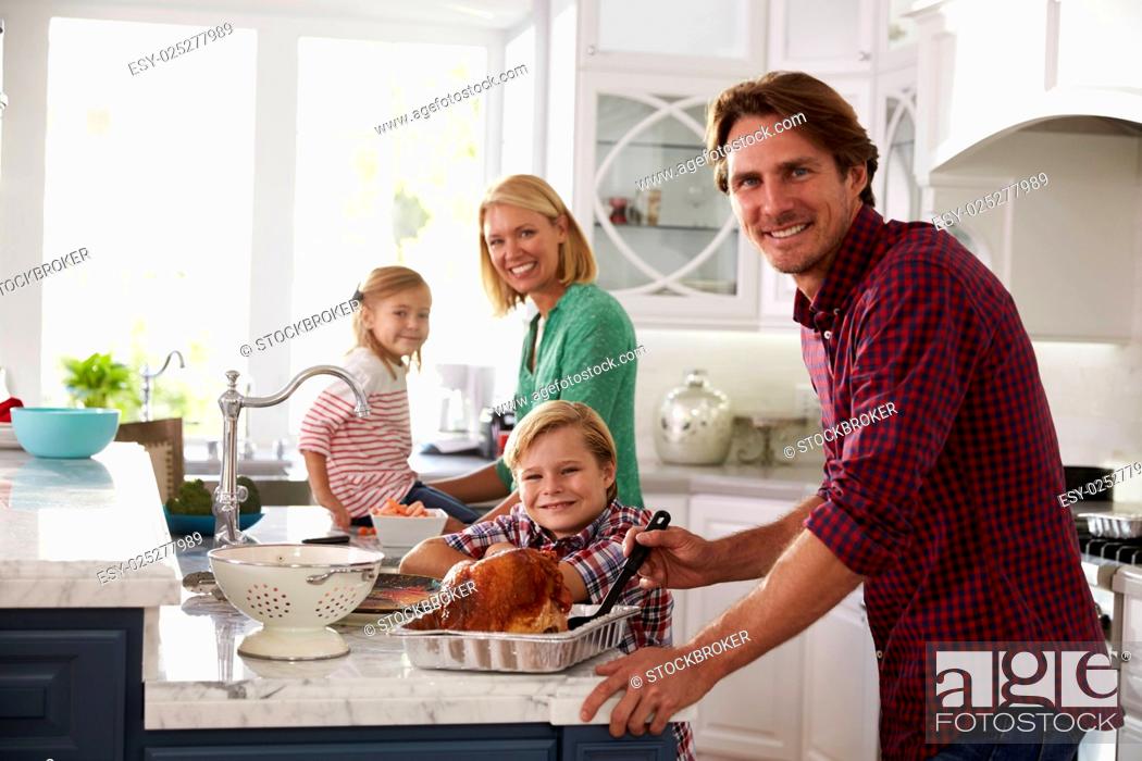 Stock Photo: Family Preparing Roast Turkey Meal In Kitchen Together.
