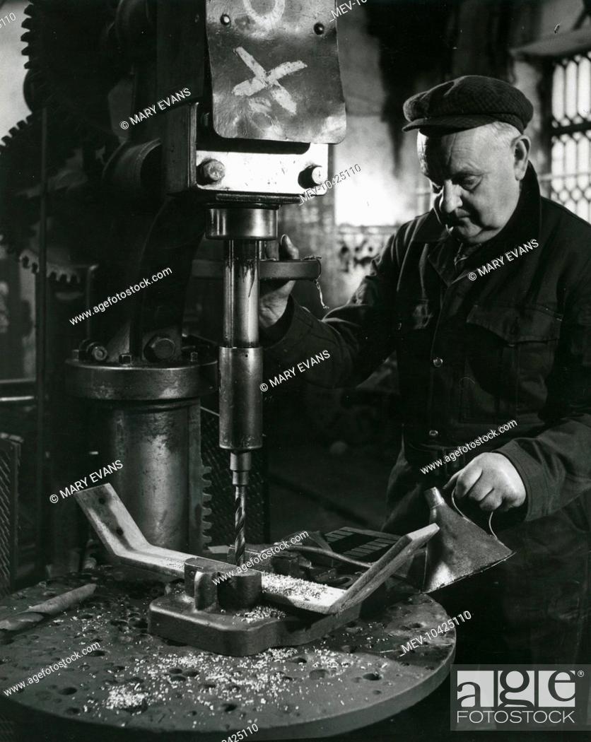 Stock Photo: A man drilling a piece of metal in the machine shop at Dinorwig (or Dinorwic) Slate Quarry, near Llanberis, North Wales. Everything was made at the works.