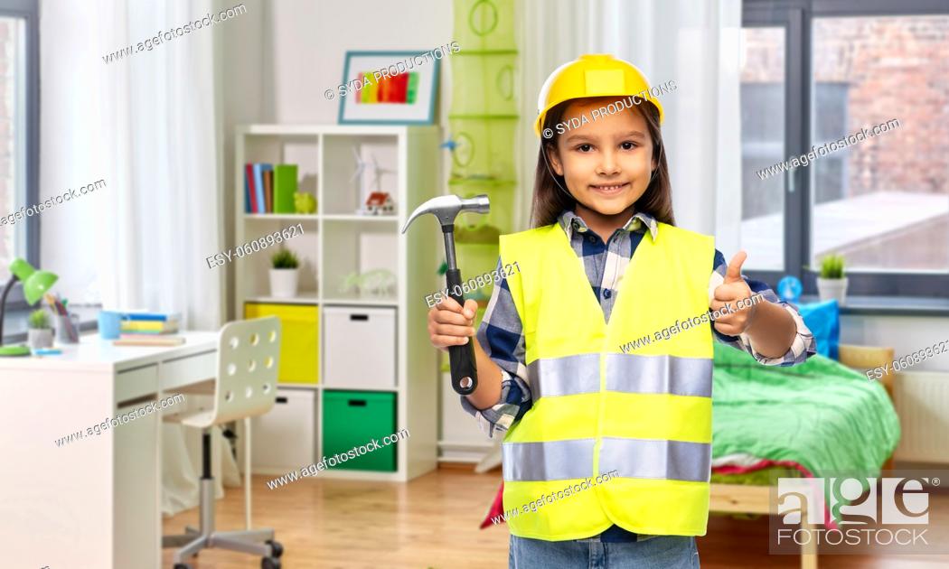 Stock Photo: happy girl with hammer showing thumbs up at home.