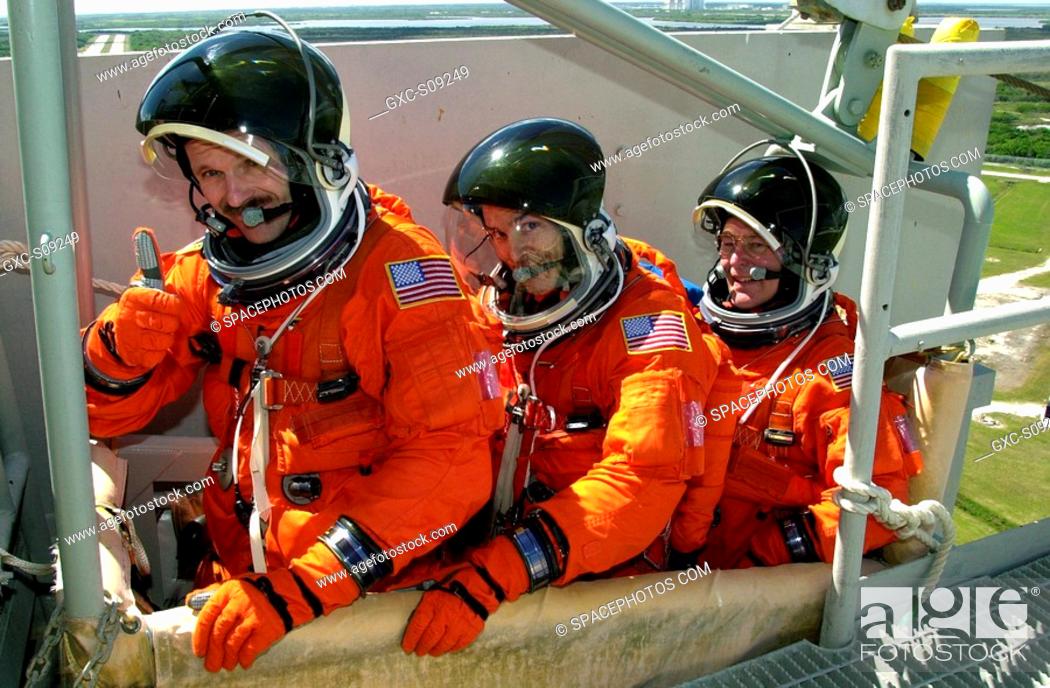 Stock Photo: 03/19/2002 -- -- STS-110 crew members sit in the slidewire basket, part of emergency egress equipment on the pad. From left are Mission Specialists Steven L.
