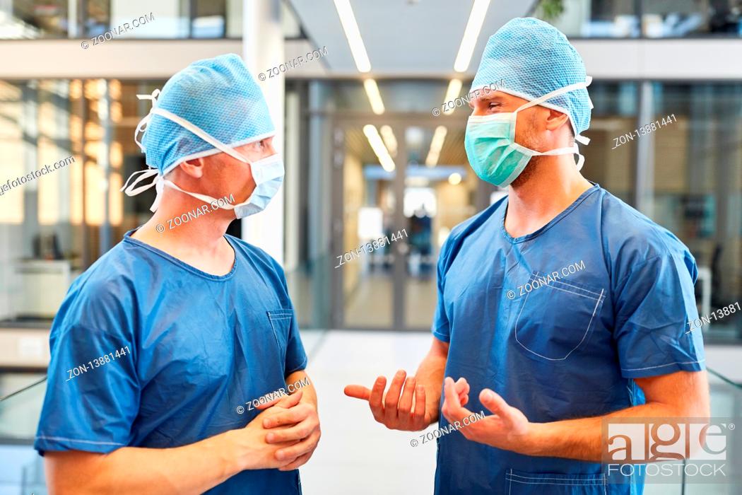 Stock Photo: Zwei Chirurgen in blauer OP-Kleidung arbeiten zusammen in der Intensivstation.