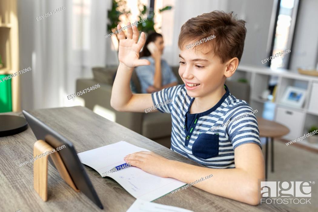 Stock Photo: boy having video calll on tablet pc at home.