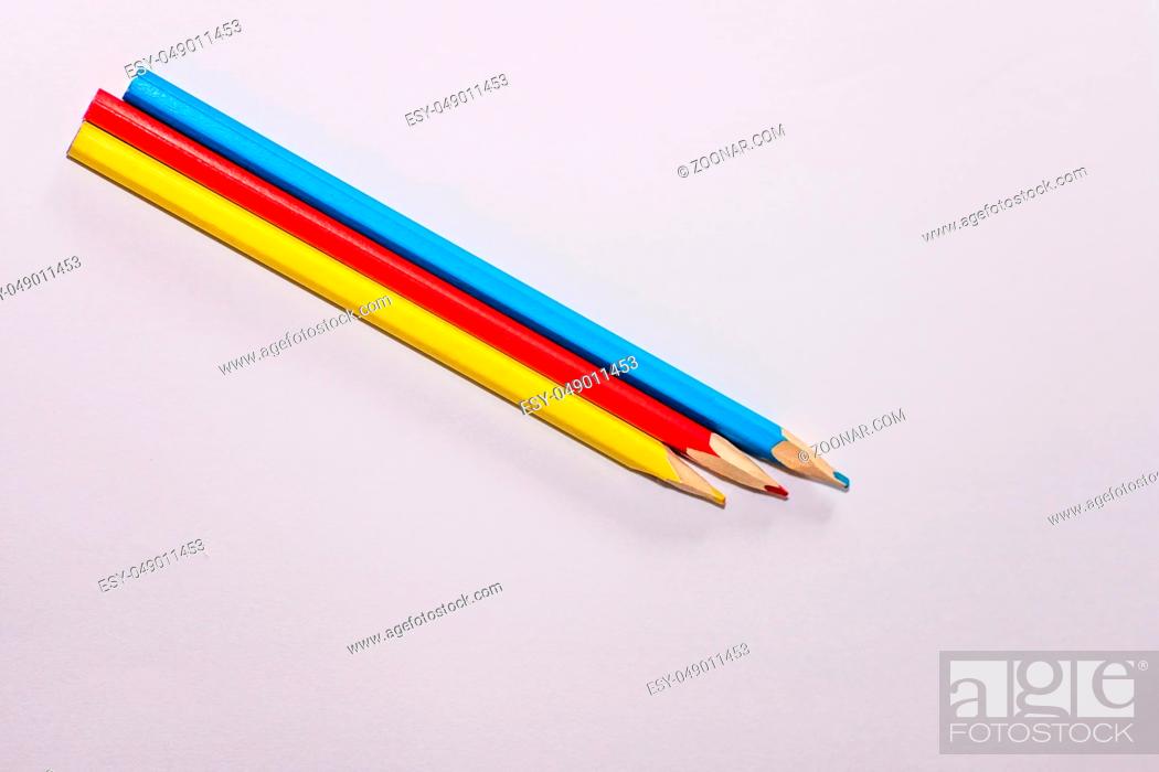 Stock Photo: Red, yellow and blue crayons and white paper sheet on the desk.