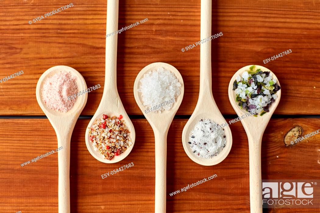 Stock Photo: spoons with salt and spices on wooden table.
