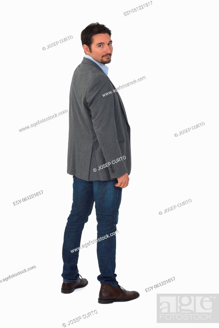 Imagen: rear view of a man with blazer and jeans looking at camera on white background.