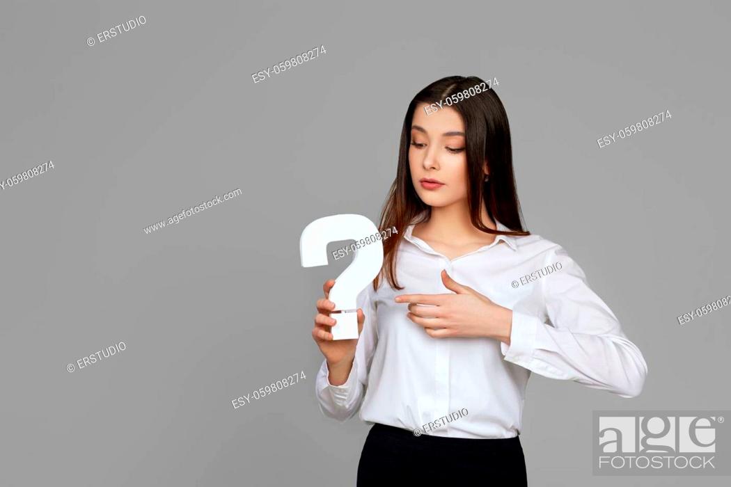Stock Photo: beautiful caucasian business woman with question mark on gray background.