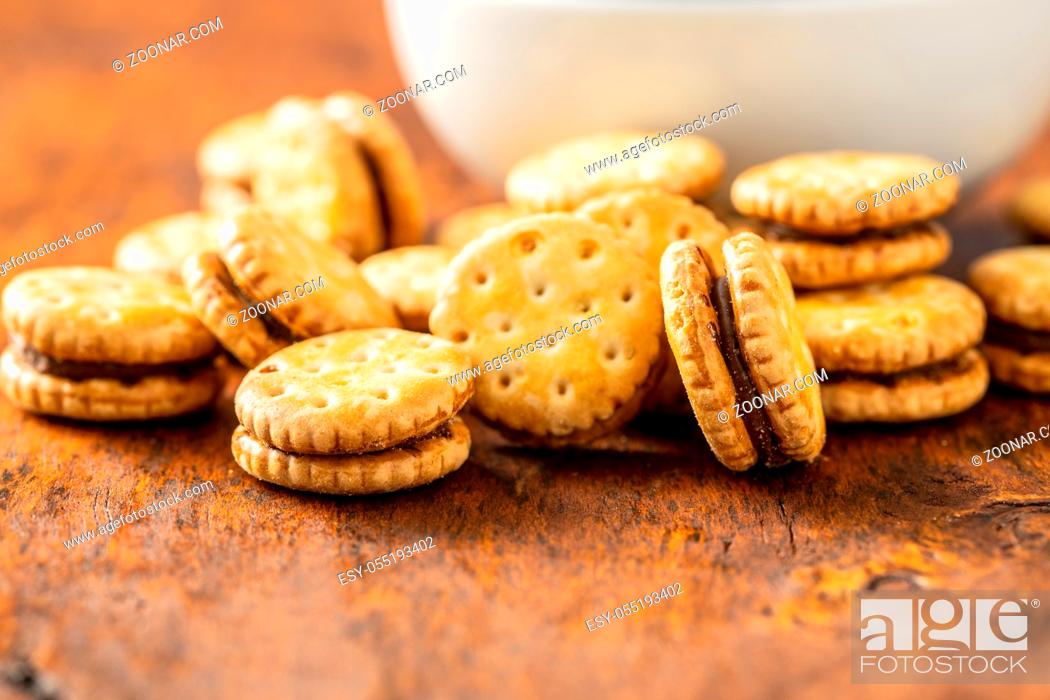 Stock Photo: Mini cream sandwich cookies on wooden table.