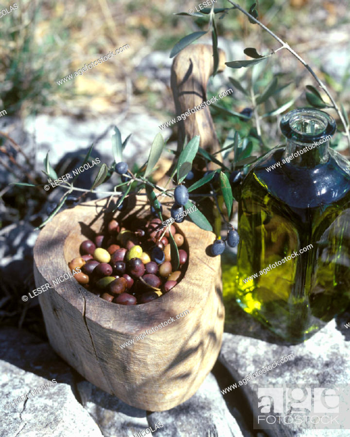 Stock Photo: A bottle of olive oil, olives nicoise in a wooden bowl (2).