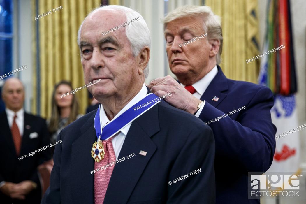 Stock Photo: US President Donald J. Trump (R) awards the Presidential Medal of Freedom to American racing magnate Roger Penske (L) during a ceremony in the Oval Office of.