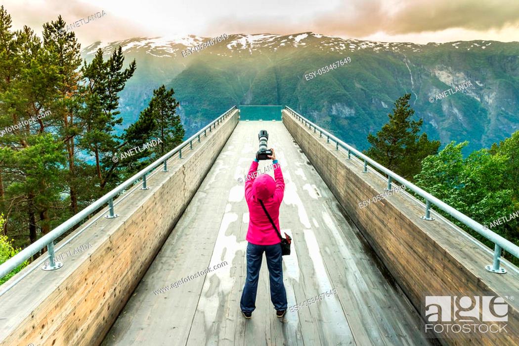 Stock Photo: Tourism and travel. Woman tourist nature photographer taking photo with camera, enjoying Aurland fjord landscape from Stegastein lookout, Norway Scandinavia.