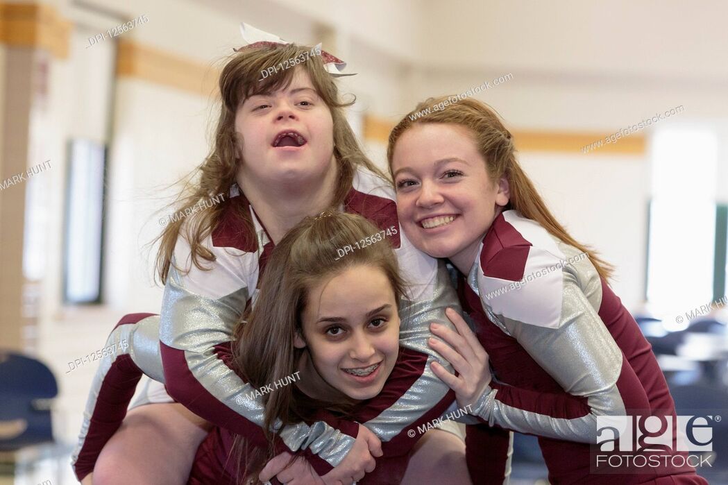 Stock Photo: Portrait of three cheerleaders having fun, one with Down Syndrome.