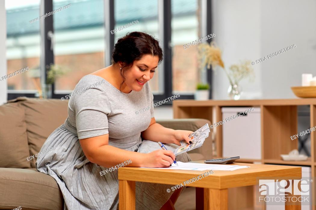 Stock Photo: woman with money, papers and calculator at home.