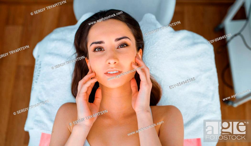 Stock Photo: Female patient on treatment table in cosmetician's office, top view. Rejuvenation procedure in beautician salon. Cosmetic surgery against wrinkles.